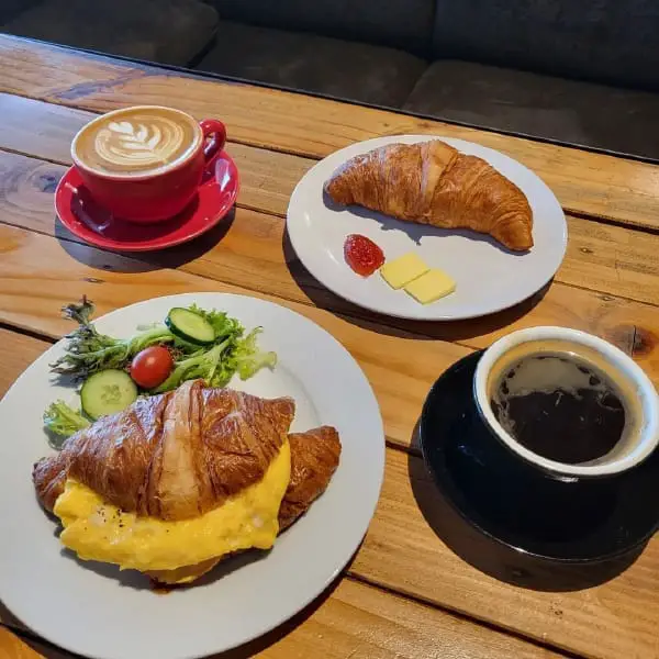 Toast With Avocado & Scrambled Eggs And Croissant Sandwich With Ham At The Coffeeholic